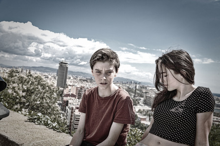 siblings sitting on a wall with Barcelona in backgroundの写真素材
