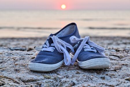 two sneakers at the beachの写真素材