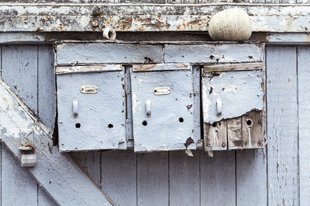 three very old and grungy mailboxes at a gateの写真素材