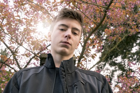 portrait of a young man in the nature with the sun behind