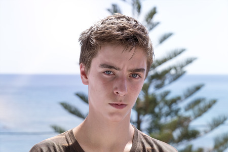 portrait of a young man with the ocean in backgroundの写真素材