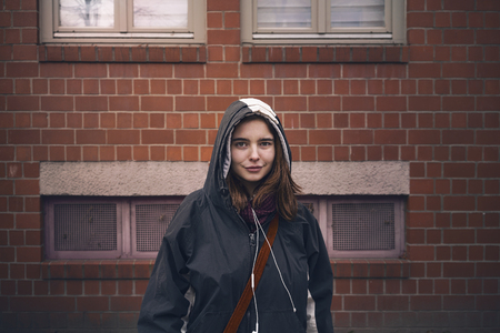 portrait of a smiling young woman with parkaの写真素材