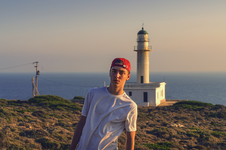 portrait of a young man in front of a lighthouse in Greeceの写真素材