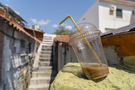 abandoned old plastic drinking cup with coffeeの写真素材