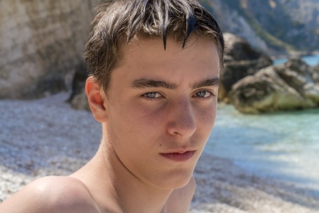 portrait of a young man sitting on a beachの写真素材