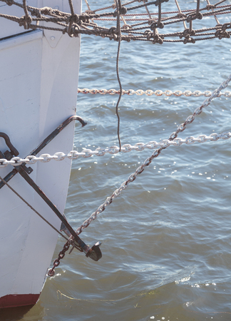 closeup of the prow of a big sailing yacht, with chains and anchor