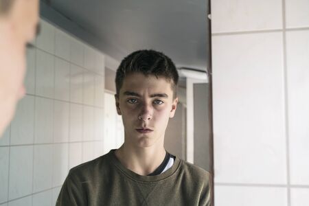 portrait of a serious young man in a mirrorの写真素材