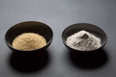 brown sugar and wheat in black asian bowlsの写真素材
