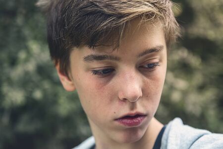 Portrait of a young man looking down, lost in thoughtの写真素材