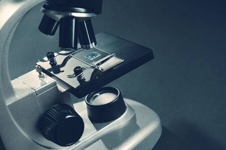 details of a silver microscope, with black background