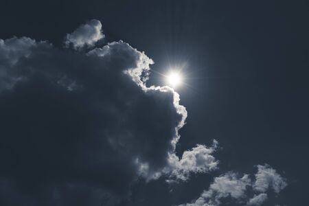 dark sky with cloudscape and sun for backgroundsの写真素材