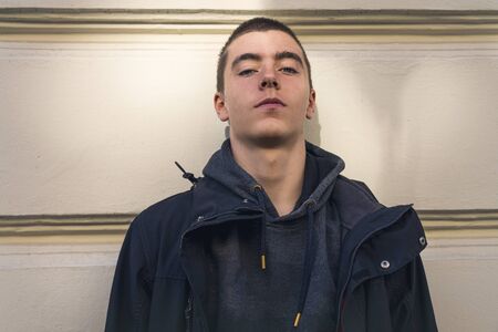 portrait of a casual young man in front of a wallの写真素材