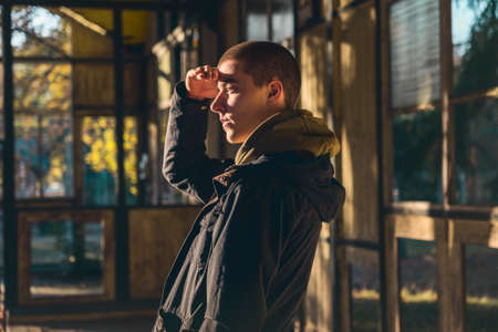 portrait of a young man in profile with evening sun looking outの写真素材