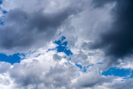 Background image, dark clouds against a blue skyの写真素材