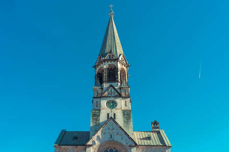 church tower with a clock against a clear blue skyの写真素材