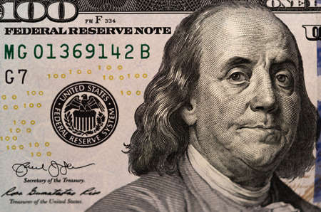 One hundred dollars and one dollar bills. Closeup of Benjamin Franklin . US dollars background. American currency. Macro.の写真素材
