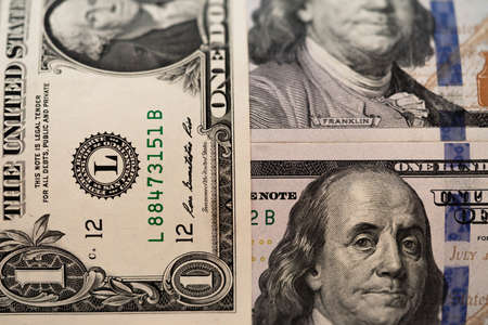 One hundred dollars and one dollar bills. Closeup of Benjamin Franklin and George Washington . US...
