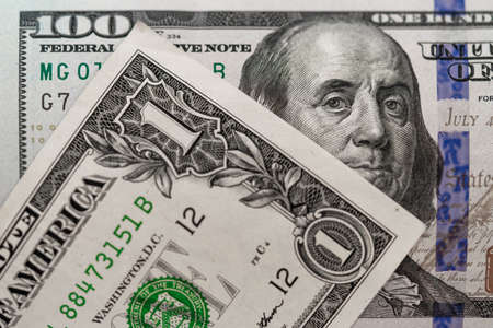 One hundred dollars and one dollar bills. Closeup of Benjamin Franklin and George Washington . US dollars background. American currency.の写真素材