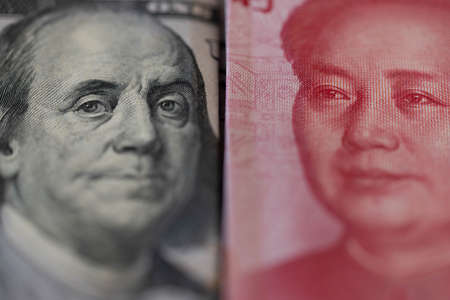 One hundred dollars and One hundred Chinese renminbi RMB bills. CNY background. Closeup of Benjamin Franklin and Mao Zedong . US dollars background. American currency.の写真素材