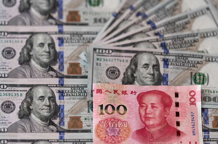 One hundred dollars and One hundred Chinese renminbi RMB bills. CNY background. Closeup of Benjamin Franklin and Mao Zedong . US dollars background. American currency.の写真素材