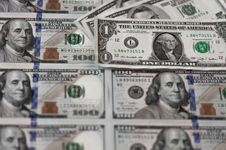 One hundred dollars and one dollar bills. Benjamin Franklin. US dollars background. Closeup of a lot of banknotes hundred dollar bills. American currency.の写真素材