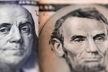 One hundred dollars and five dollar bills. Closeup of Benjamin Franklin and Abraham Lincoln . US...