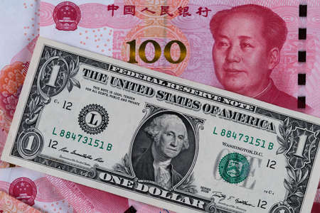 One dollar and One hundred Chinese renminbi RMB bills. CNY background. Closeup of Benjamin Franklin and Mao Zedong . US dollars background. American currency. Chinese currency. Chinaの写真素材
