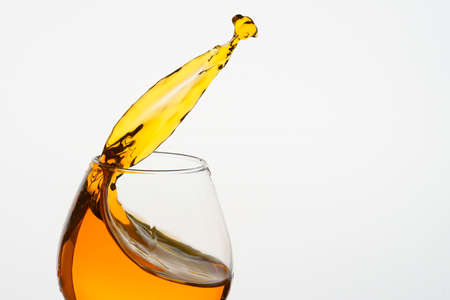 Freeze Action Photography .Splash of Cognac In glass Isolated on White.の写真素材