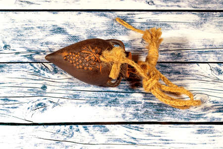 Handmade clay jug  with grape pattern with ropes attached on wooden background.の写真素材