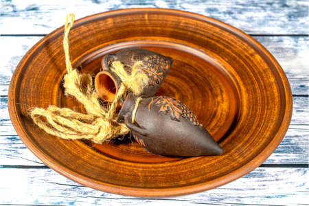 Handmade clay jugs  with grape pattern with ropes attached on clay plateの写真素材