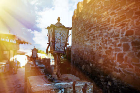 Vintage  Iron street lamp on a stone stand with blue sky background .の写真素材