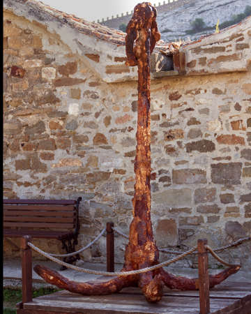 Big old rusty anchor on a wooden stand.の写真素材