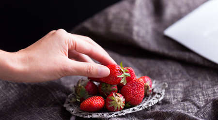 female hand pick up strawberry, Closeup of  hands holding strawberriesの写真素材