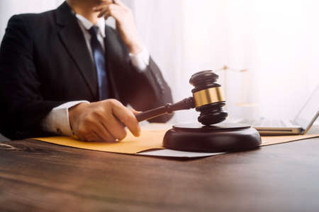 Business and lawyers discussing contract papers with brass scale on desk in office. Law, legal services, advice, justice and law concept picture with film grain effectの写真素材