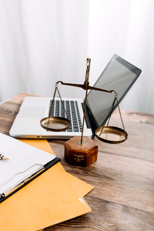 Business and lawyers discussing contract papers with brass scale on desk in office. Law, legal services, advice, justice and law concept picture with film grain effectの写真素材