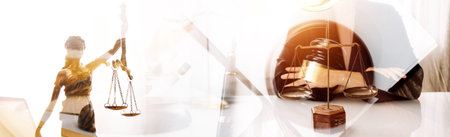 Justice and law concept.Male judge in a courtroom with the gavel, working with, computer and docking keyboard, eyeglasses, on table in morning lightの写真素材