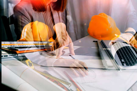 Two colleagues discussing data working and tablet, laptop with on on architectural project at...