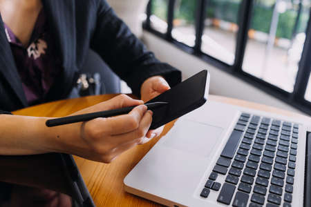 Businessman and team analyzing financial statement Finance task. with smart phone and laptop and...