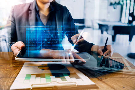 Businessman and team analyzing financial statement Finance task. with smart phone and laptop and...