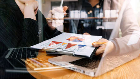 Businessman and team analyzing financial statement Finance task. with smart phone and laptop and...