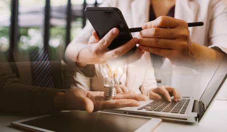 Businessman and team analyzing financial statement Finance task. with smart phone and laptop and...