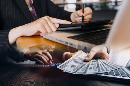 Businessman and team analyzing financial statement Finance task. with smart phone and laptop and...