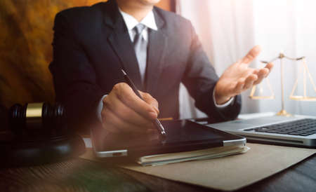 Justice and law concept.Male judge in a courtroom with the gavel, working with, computer and docking...