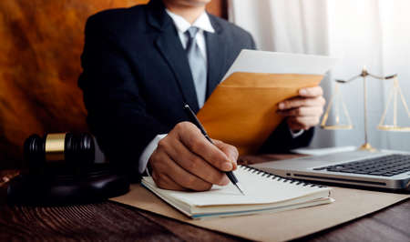 justice and law concept.Male judge in a courtroom on wooden table and Counselor or Male lawyer...