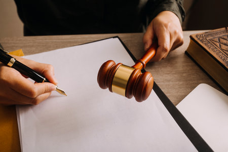 Male lawyer working with contract papers and wooden gavel on tabel in courtroom. justice and law...