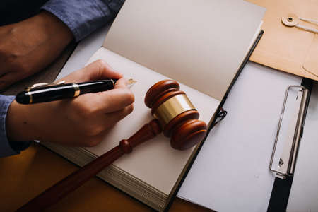 Male lawyer working with contract papers and wooden gavel on tabel in courtroom. justice and law...