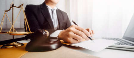Justice and law concept.Male judge in a courtroom with the gavel, working with, computer and docking...