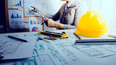 Two colleagues discussing data working and tablet, laptop with on on architectural project at...