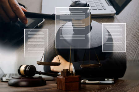 Male lawyer working with contract papers and wooden gavel on tabel in courtroom. justice and law...