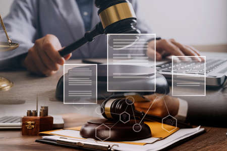 Male lawyer working with contract papers and wooden gavel on tabel in courtroom. justice and law...